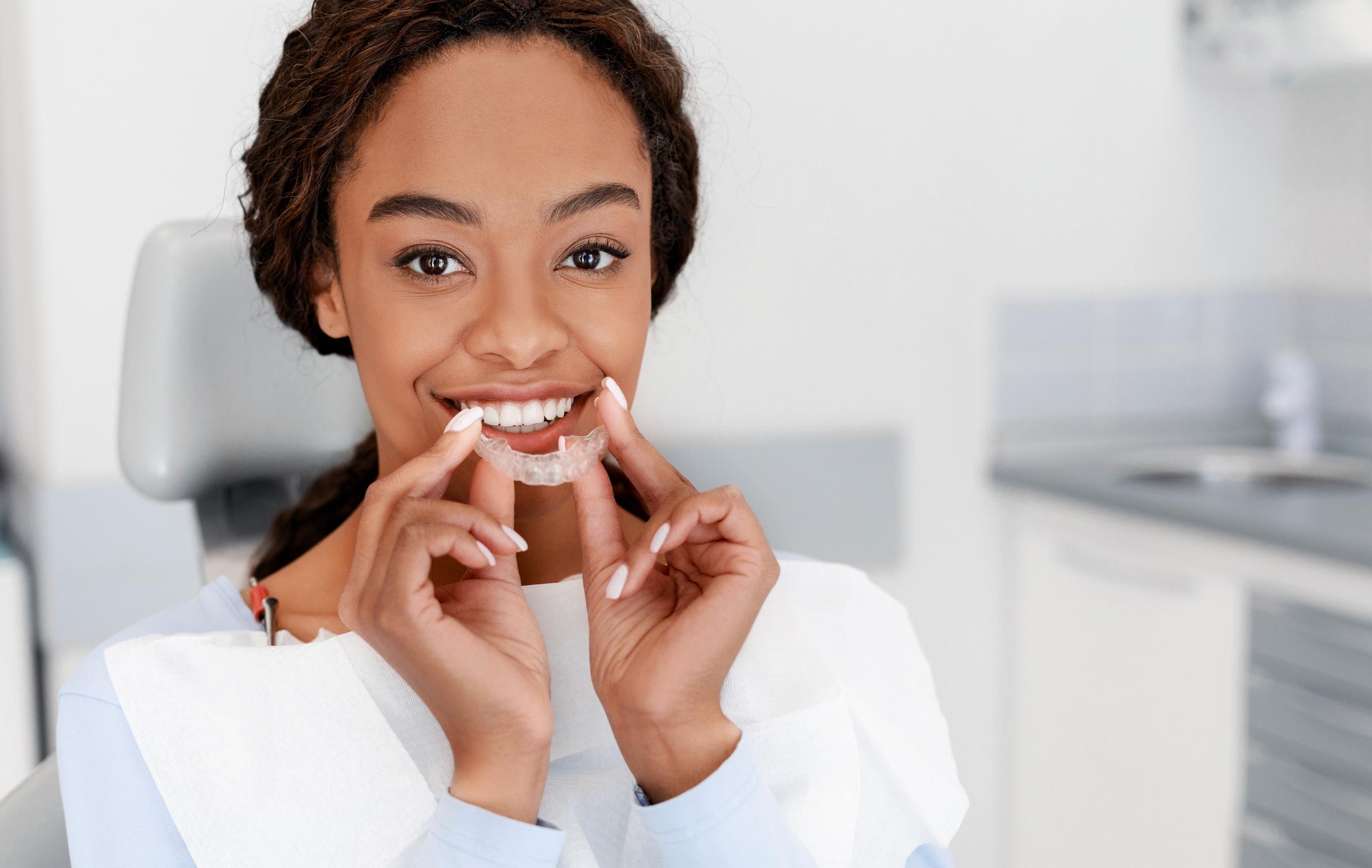 woman holding ClearCorrect invisable aligners