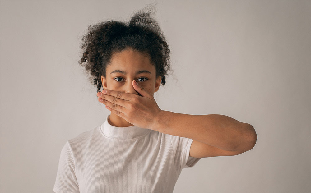 Girl covering her mouth