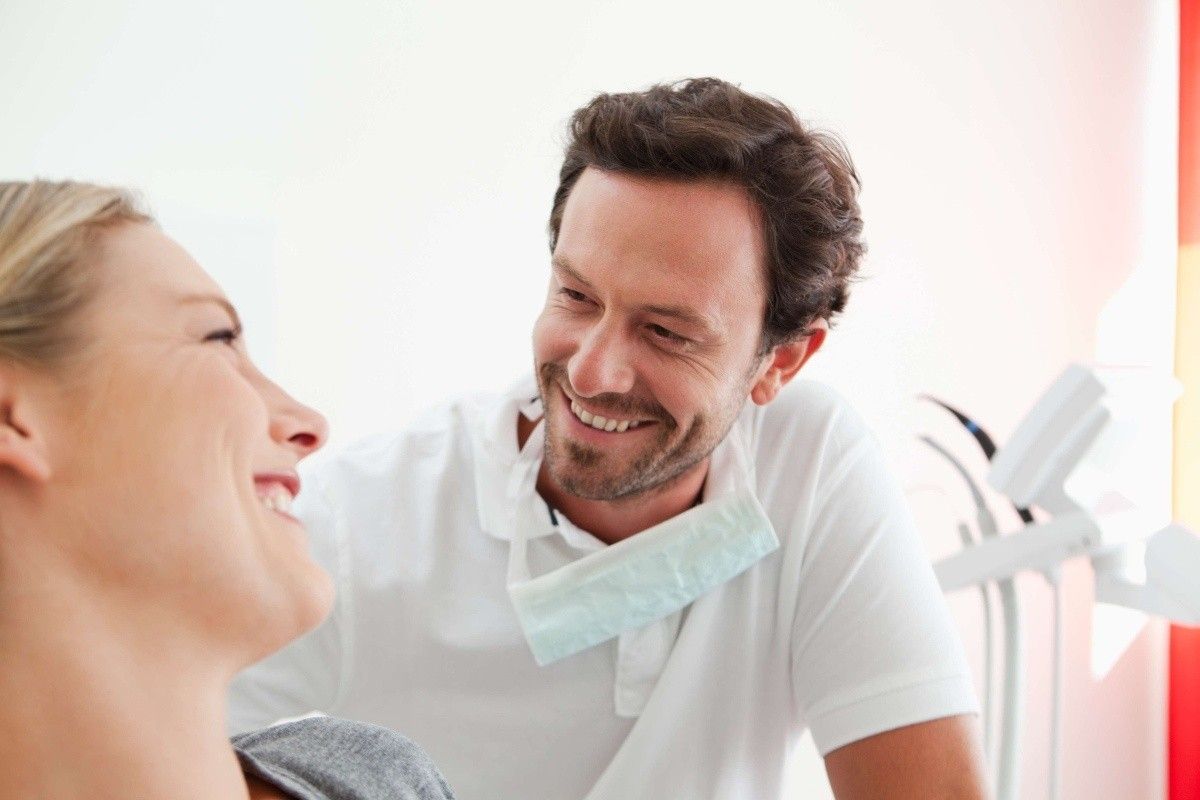 Dentist discussing clear aligner treatment options with an adult patient