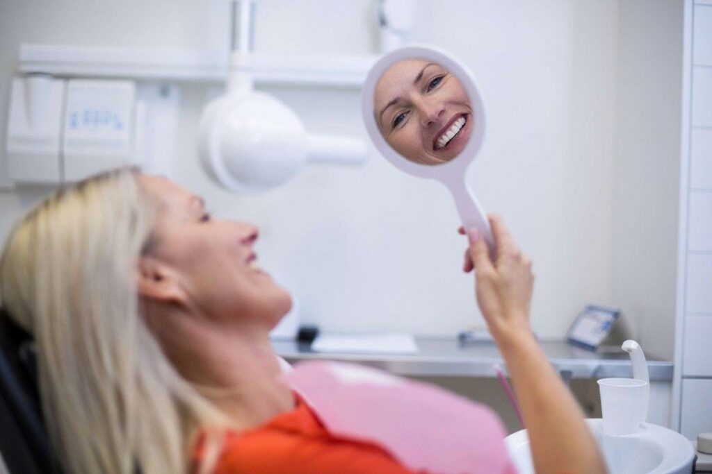 Patient smiling while viewing cosmetic dentistry results during a smile consultation