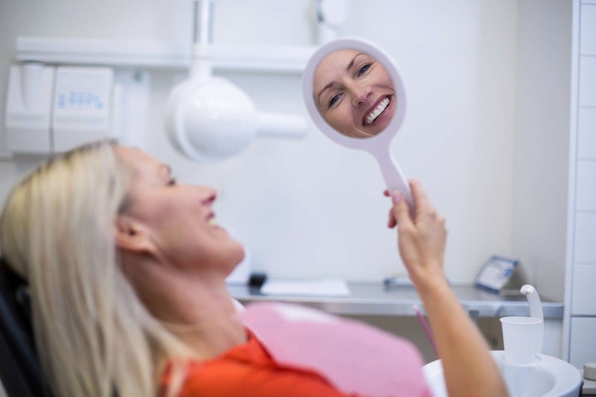 Patient smiling while viewing cosmetic dentistry results during a smile consultation