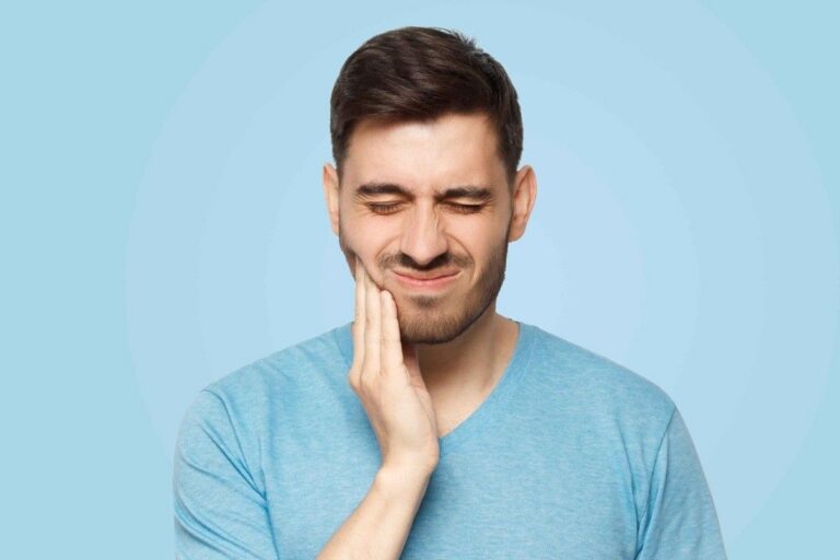 Man holding his jaw due to severe tooth pain, representing a dental emergency