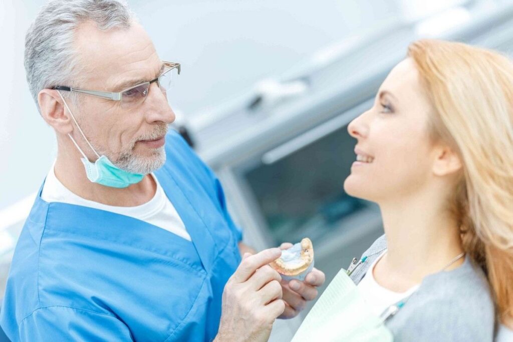 Dentist discussing clear aligner treatment options with a patient during a smile assessment.